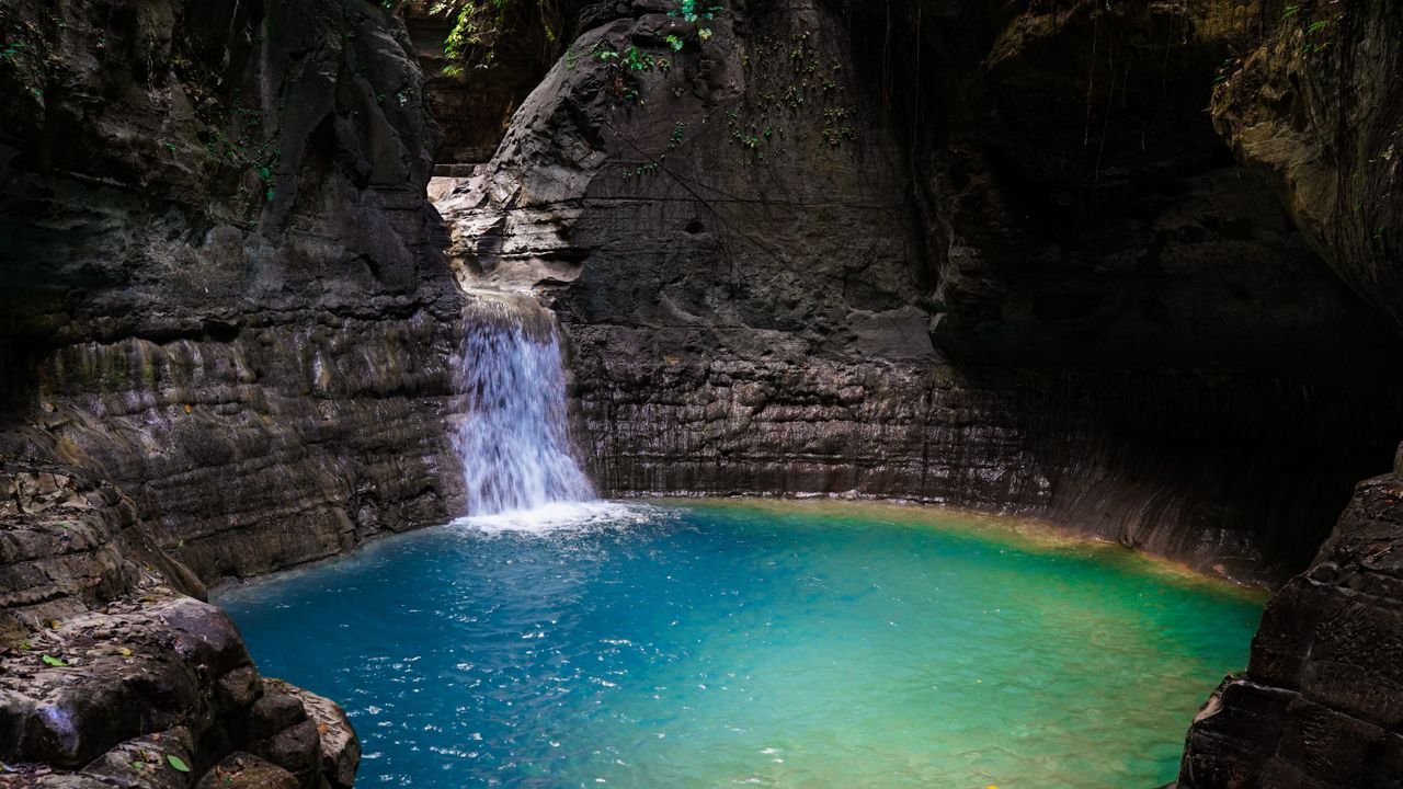 Discover the tranquil beauty of Waimarang Waterfall with its clear blue waters and rocky surrounds.