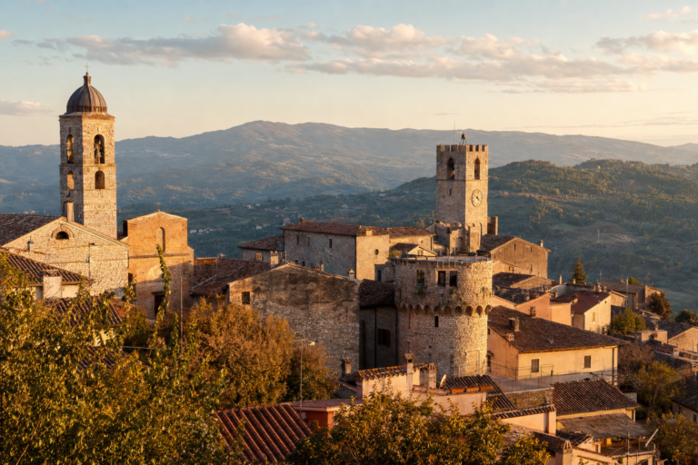 Hilltop Italian town at golden hour, representing underrated towns worth a detour
